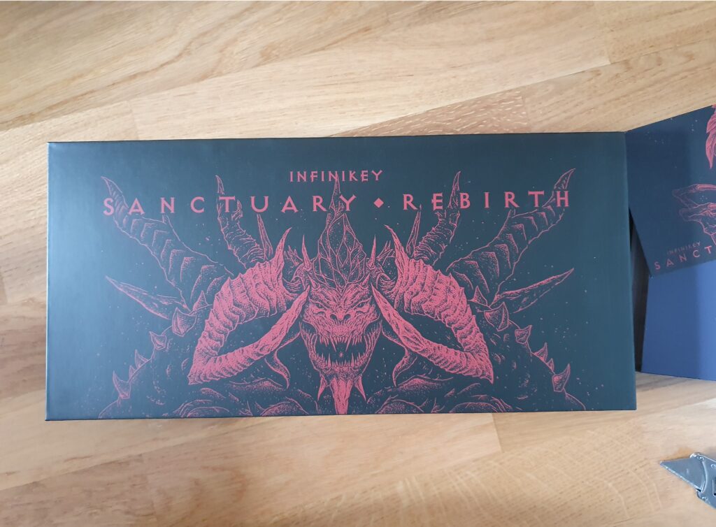 Esken til Infinikey Sanctuary Rebirth. Den er sort med rød tekst. Under teksten er et stort djevelhode med bukkehorn.